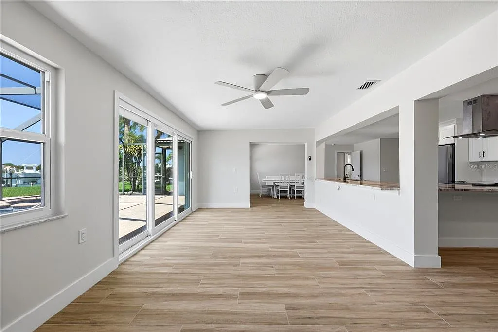 Wood-look porcelain tile flooring in an open living room with sliding glass doors and water view in St. Petersburg, FL